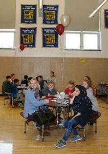 picture of students and teacher seated around lunch table talking