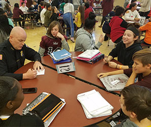 picture of students and police chief seated around lunch table talking