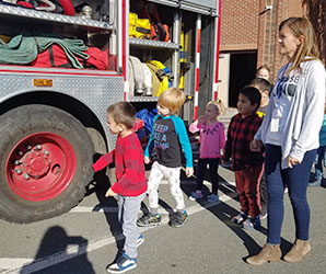 picture of students and teacher walking alongside a fire engine