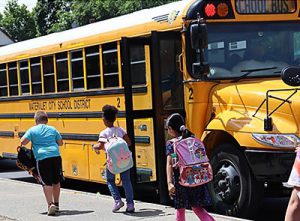 Elementary students walk toward the school bus
