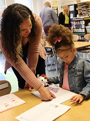 A parent and elementary student participate in a drawing activity