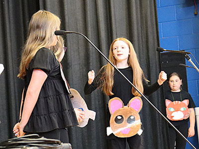 Four drama club students perform a skit on stage 