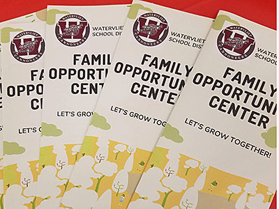 four family opportunity center brochures in a staggered stack on table with red tablecloth