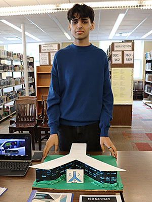 A student stands ready to present a Collaborative City project, a carwash located at the airport 