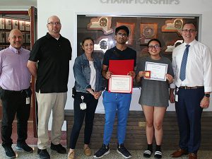 High school guidance counselor, science department chairperson, high school principal and superintendent of schools stand on either side of the two scholarship winners