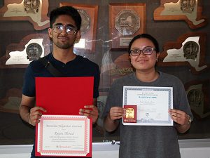 High school juniors hold science scholarship awards and smile for the camera