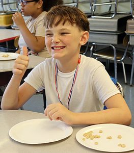 A student gives the thumbs up after winning a challenge during minute to win it Olympics