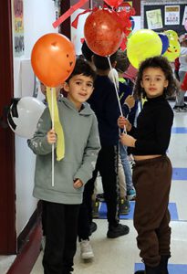 Students line up in the hallway holding their ballons