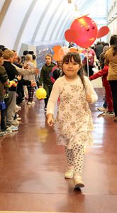 A student holds a balloon and marches through the fourth-grade wing.