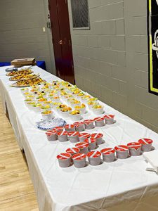 Breakfast foods lined up on long cafeteria table  