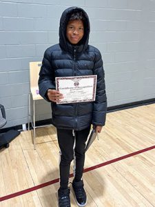 A student holds Kids of Character certificate