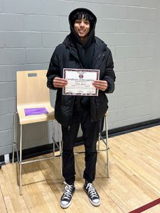 A student holds Kids of Character certificate