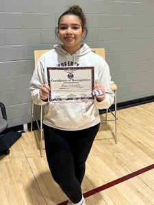 A student holds Kids of Character certificate