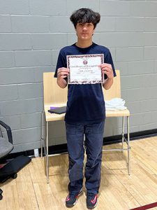 A student holds Kids of Character certificate