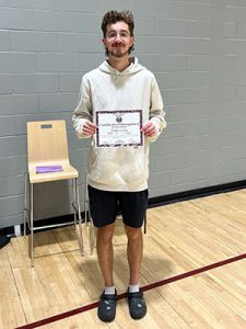 A student holds Kids of Character certificate