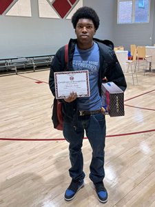 A student holds Kids of Character certificate