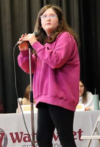 A student stands at the microphone ready to compete in spelling bee