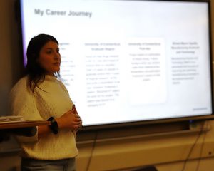 A scientist stands in front of class speaking to students about careers