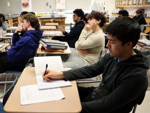 A student takes notes as scientists discuss biotech careers