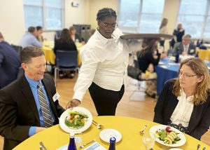 Culinary student delivers meals to guests attending a meeting